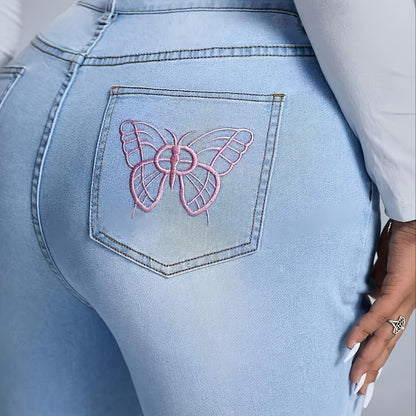 Close-up of back pocket on plus size women's flare jeans with pink embroidered butterfly design on light blue stretch denim fabric.