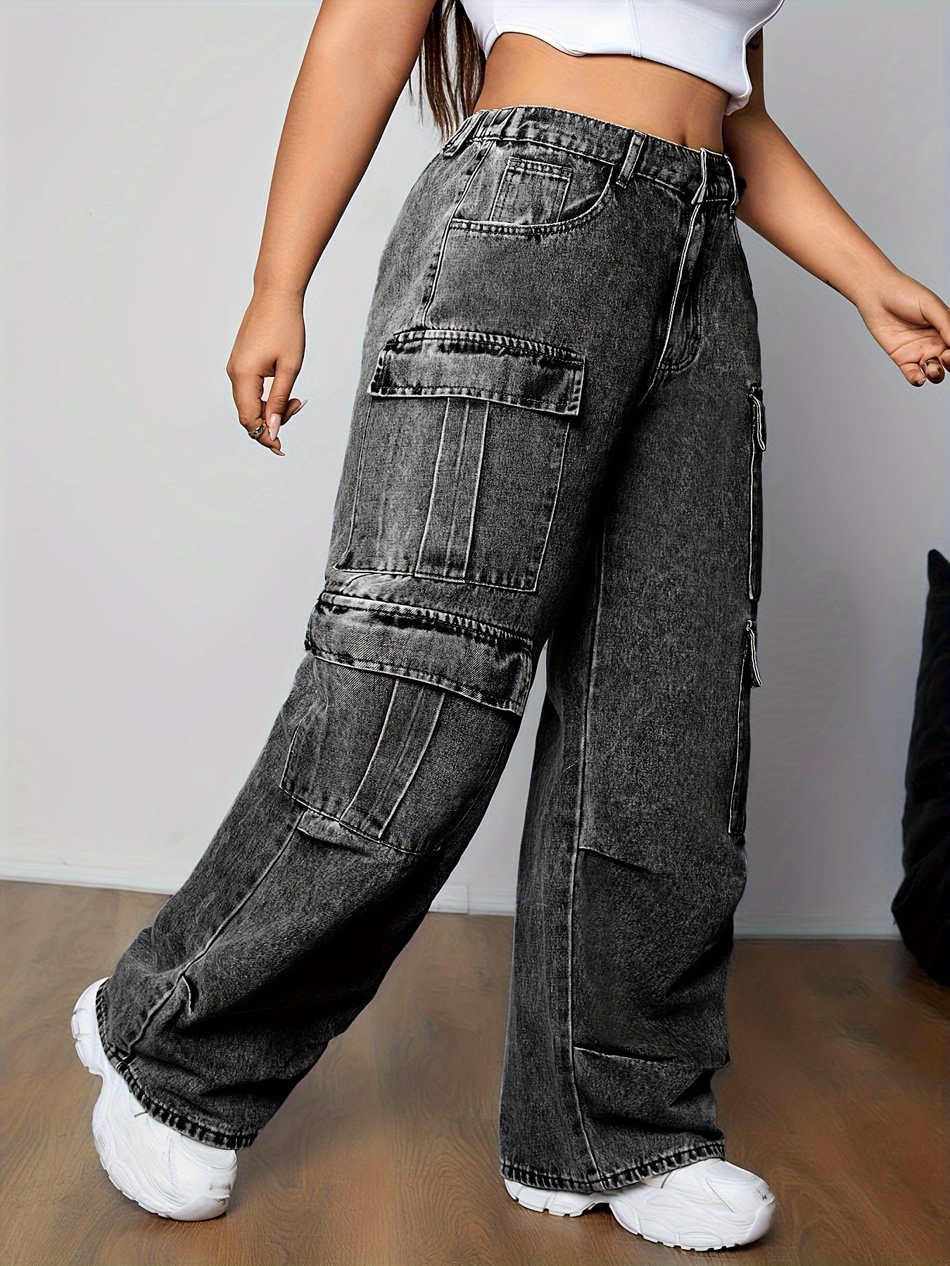 Woman wearing stylish plus size cargo jeans with multi-pocket design and side flap pockets, showcasing streetwear style.