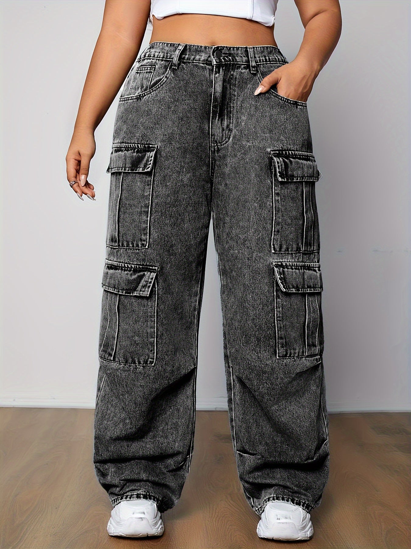 Stylish plus-size cargo jeans for women with multi-pocket design and side flap pockets in loose fit denim, ideal for streetwear and casual wear.