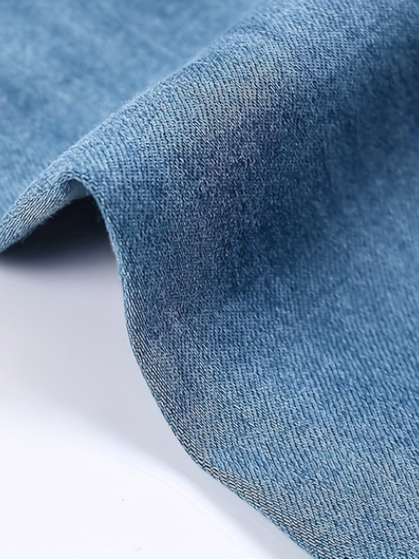 Close-up view of blue denim fabric from Plus Size Curvy Fit Casual Jeans showcasing high-quality texture and solid color.