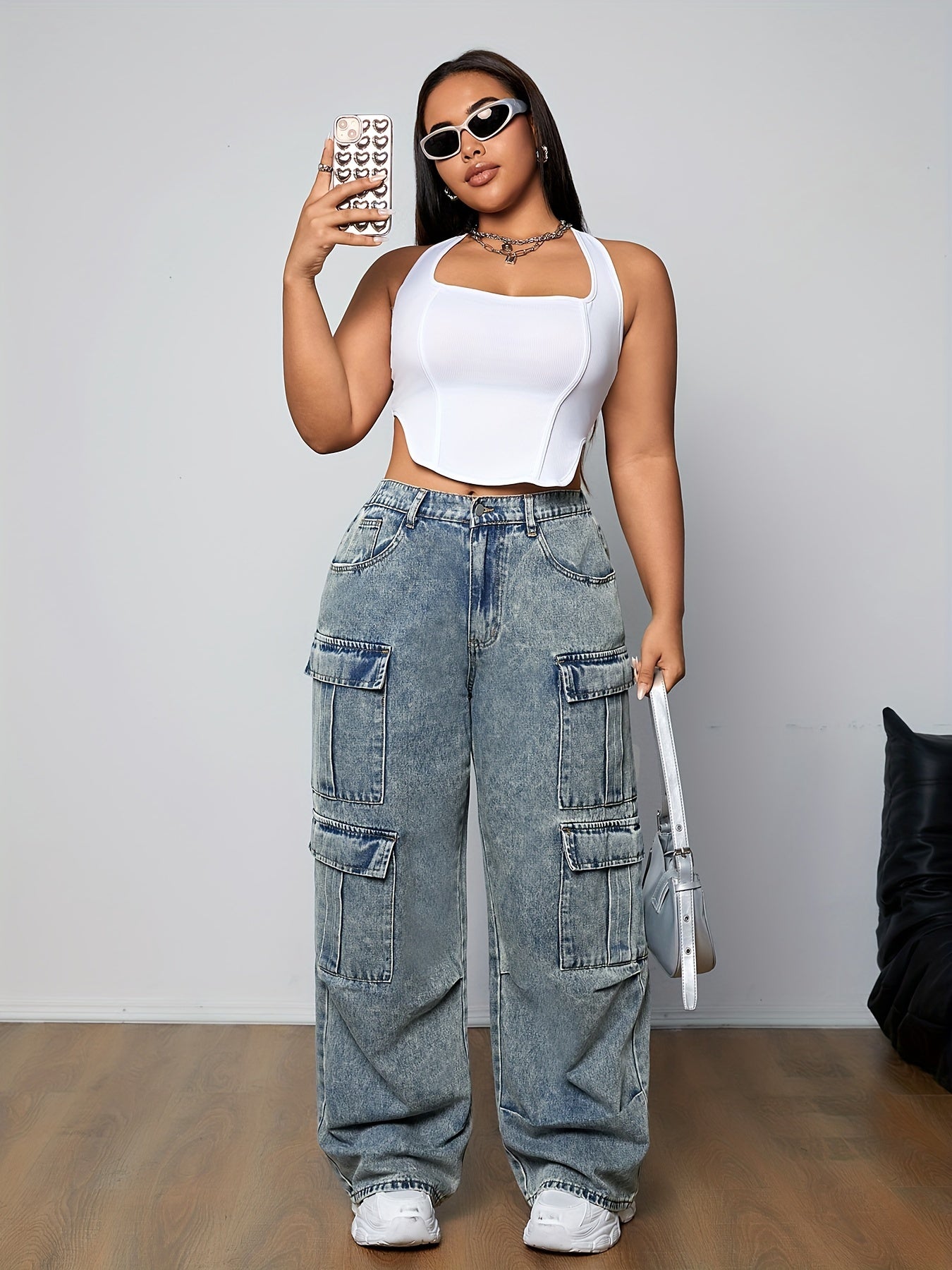 Woman wearing stylish plus size loose fit cargo jeans with multi-pocket design, streetwear style, and side flap pockets.