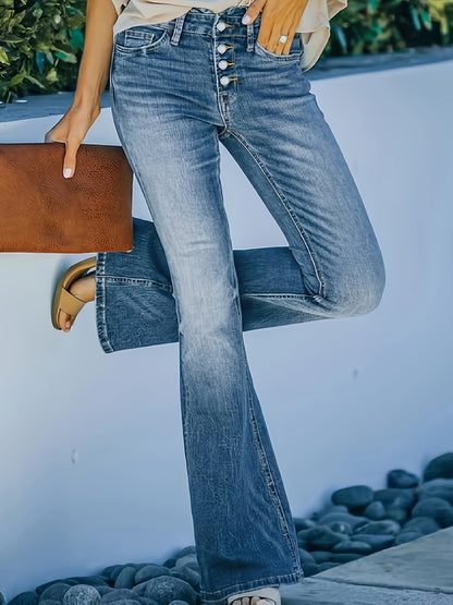 Woman wearing plus size stretchy blue bell bottom flare leg jeans with button fly and holding a brown clutch.