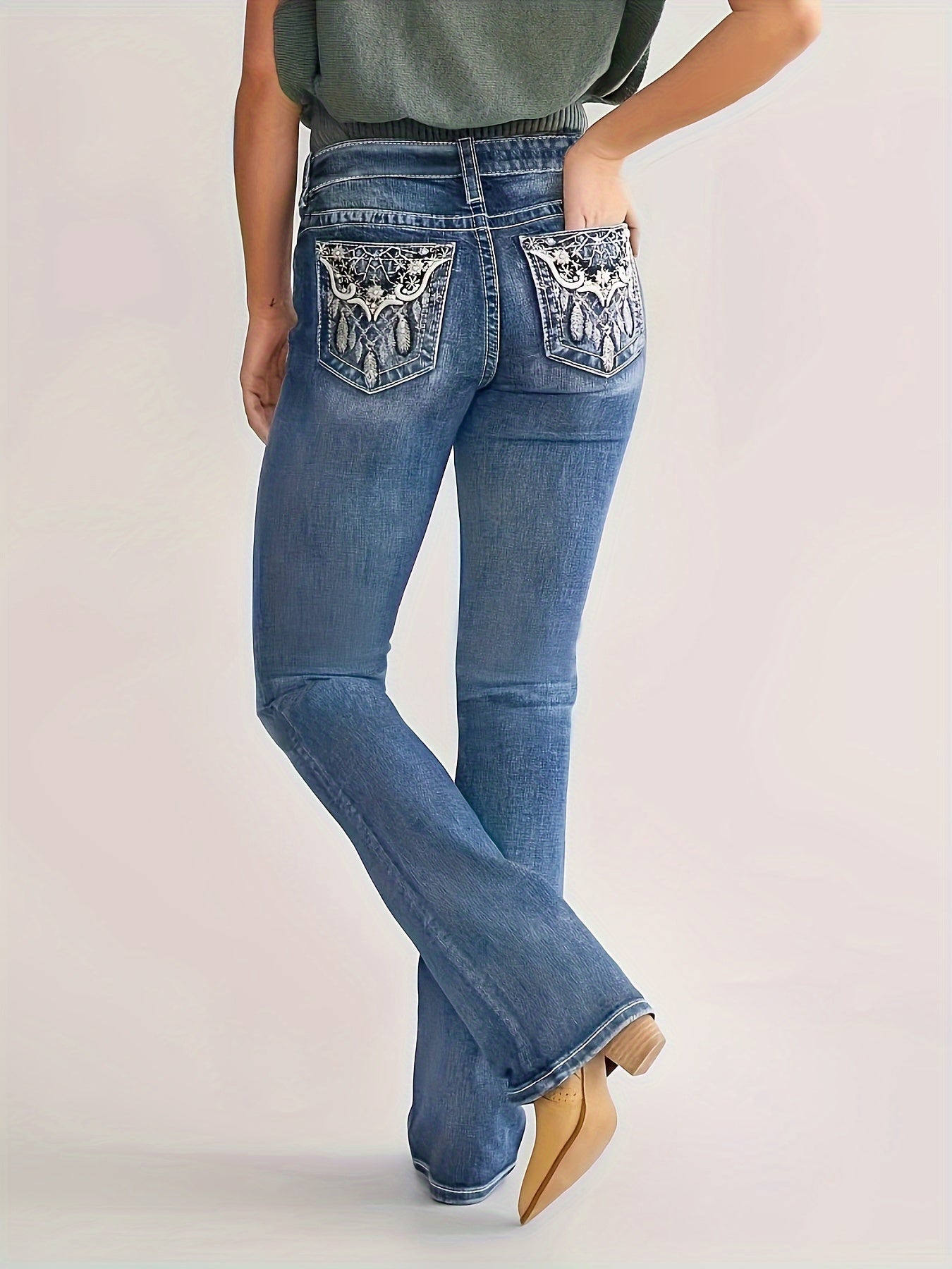 Plus size bootcut denim jeans with embroidery, whiskering, and washed blue vintage style. High stretch casual zipper button closure.