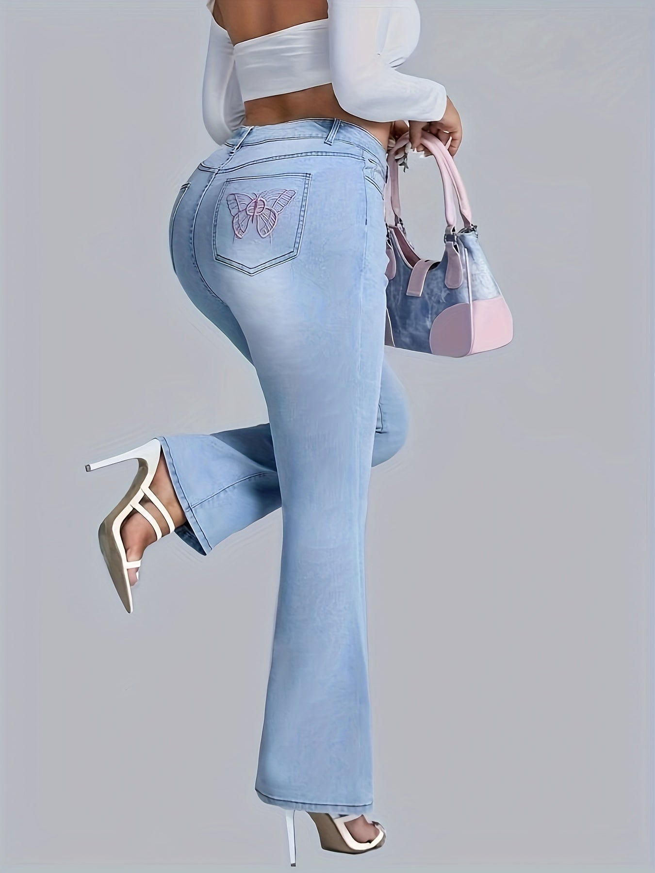 Chic plus size women's flare jeans with embroidered butterfly, casual style, medium stretch denim, perfect for all seasons.