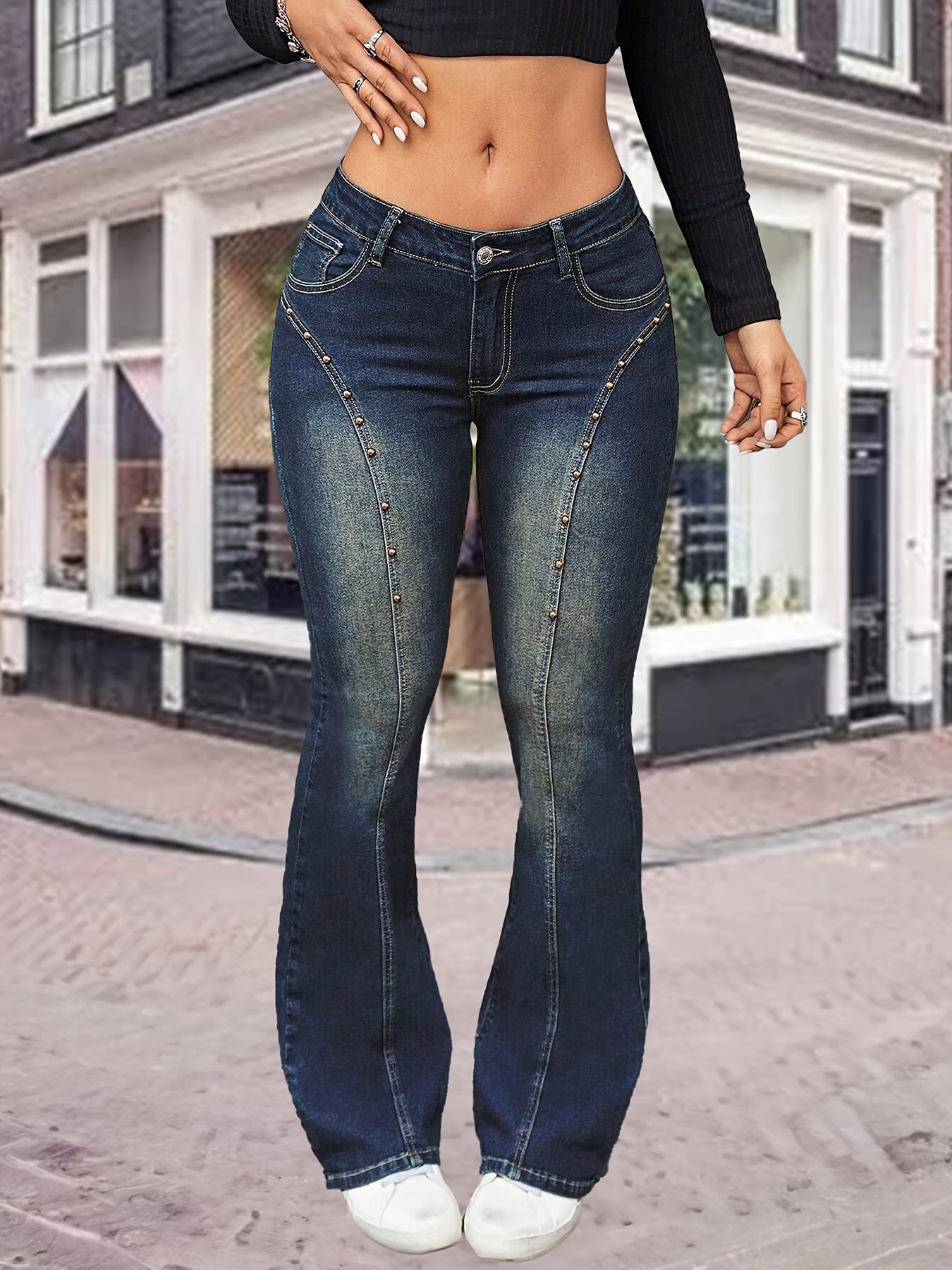 Plus size women's flared denim jeans with high waist, stretchy fabric, bell-bottom design, and pocket detail, worn by a model in streetwear fashion