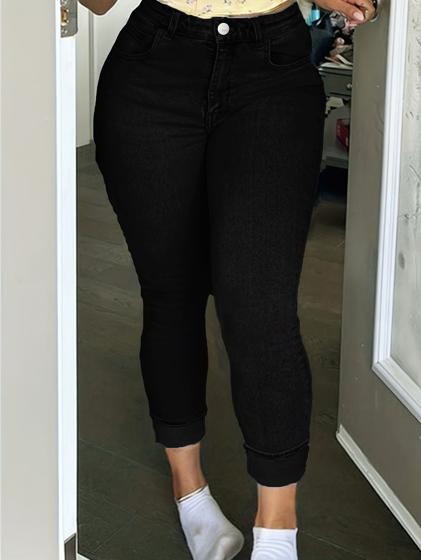 Plus size women's black skinny fit denim pants with button and zipper closure, high waist, soft stretchy fabric, casual style.