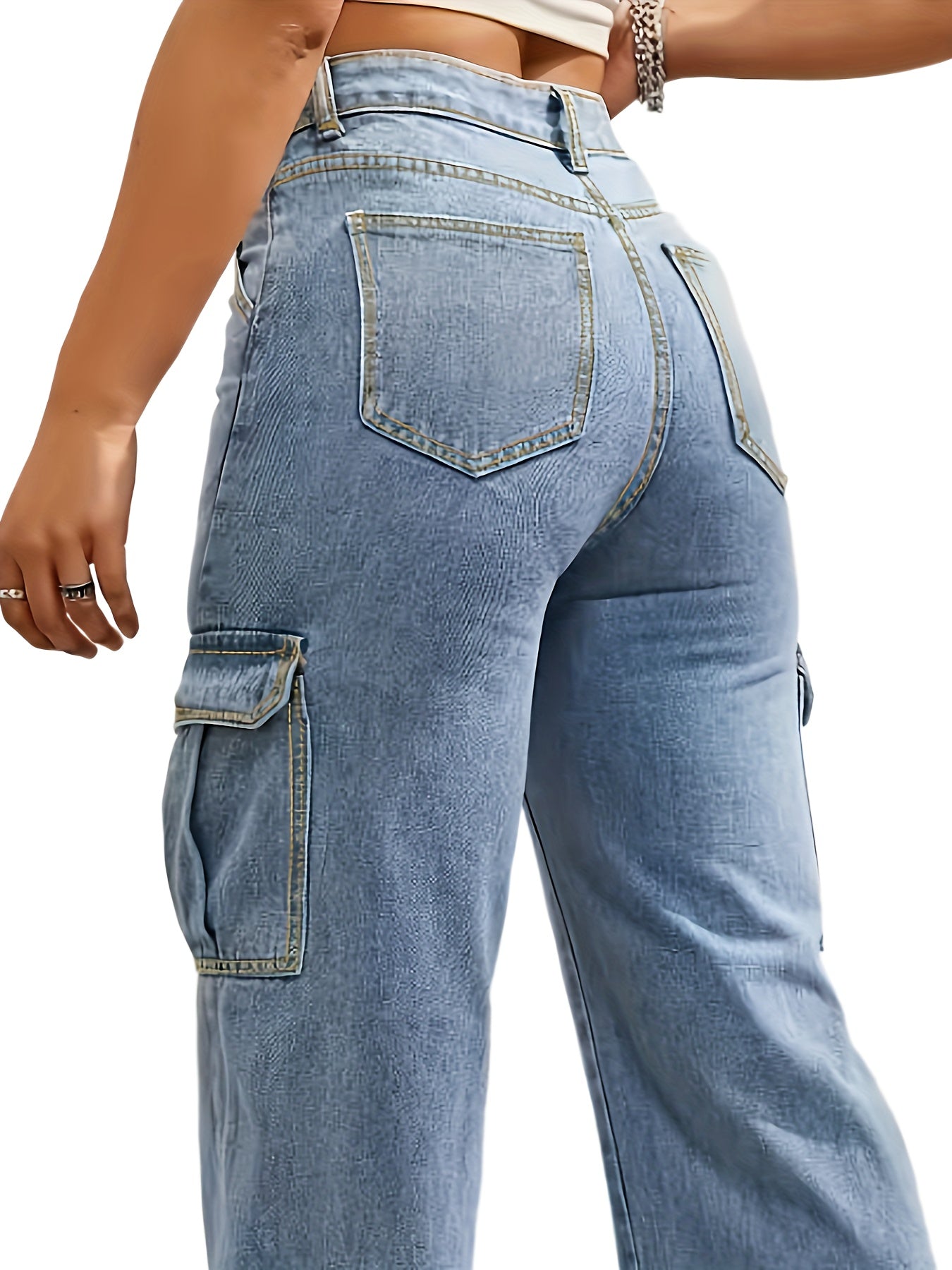 Women's stylish plus size washed blue loose fit cargo jeans with side flap pockets, streetwear inspired, rear view.