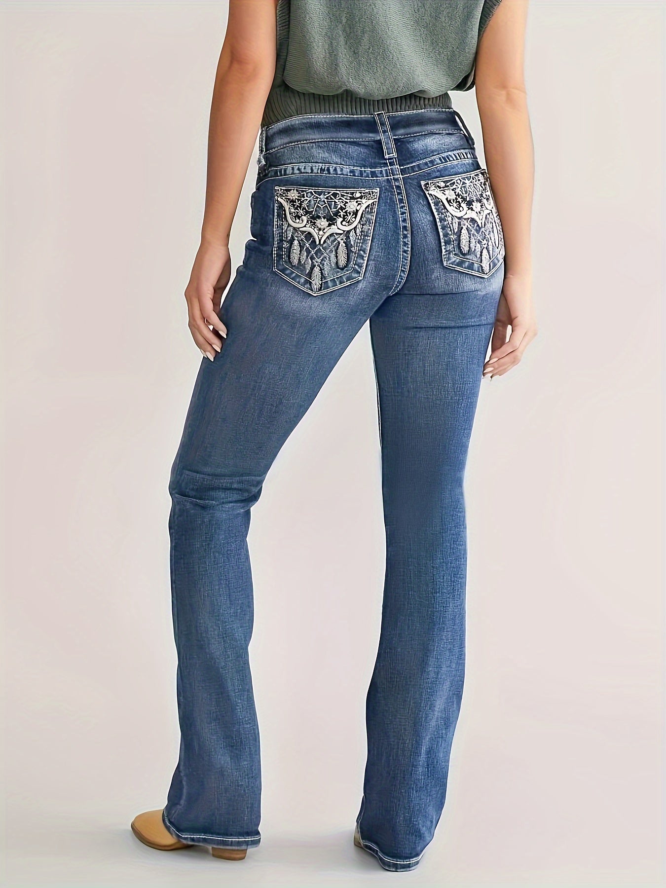 Woman wearing plus size blue bootcut denim pants with embroidery pocket detail, high stretch vintage style.