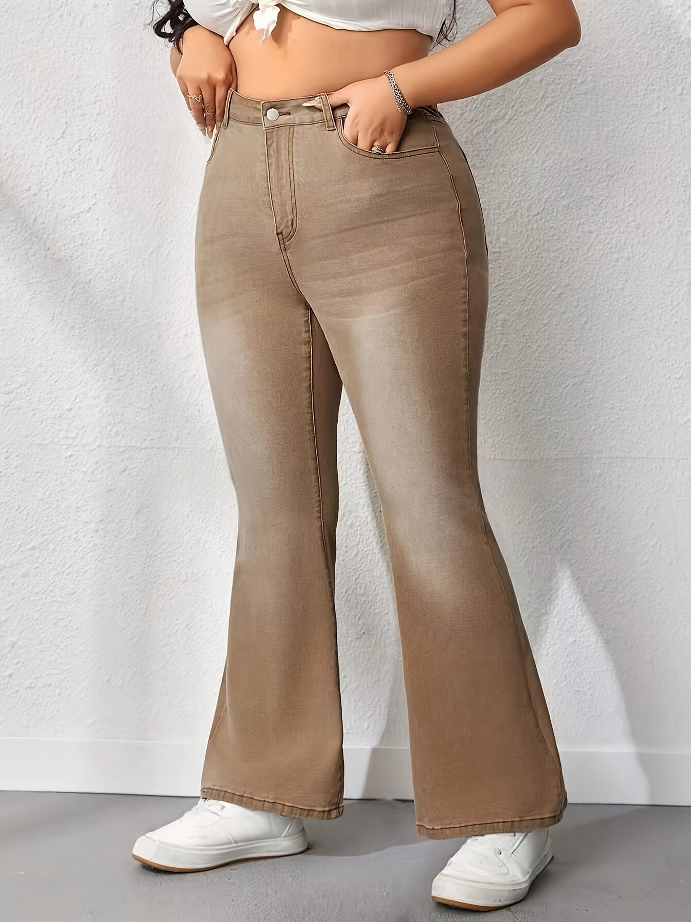 Plus size washed brown flare leg high rise bell bottom jeans in casual style for women, made of denim with medium stretch fabric.