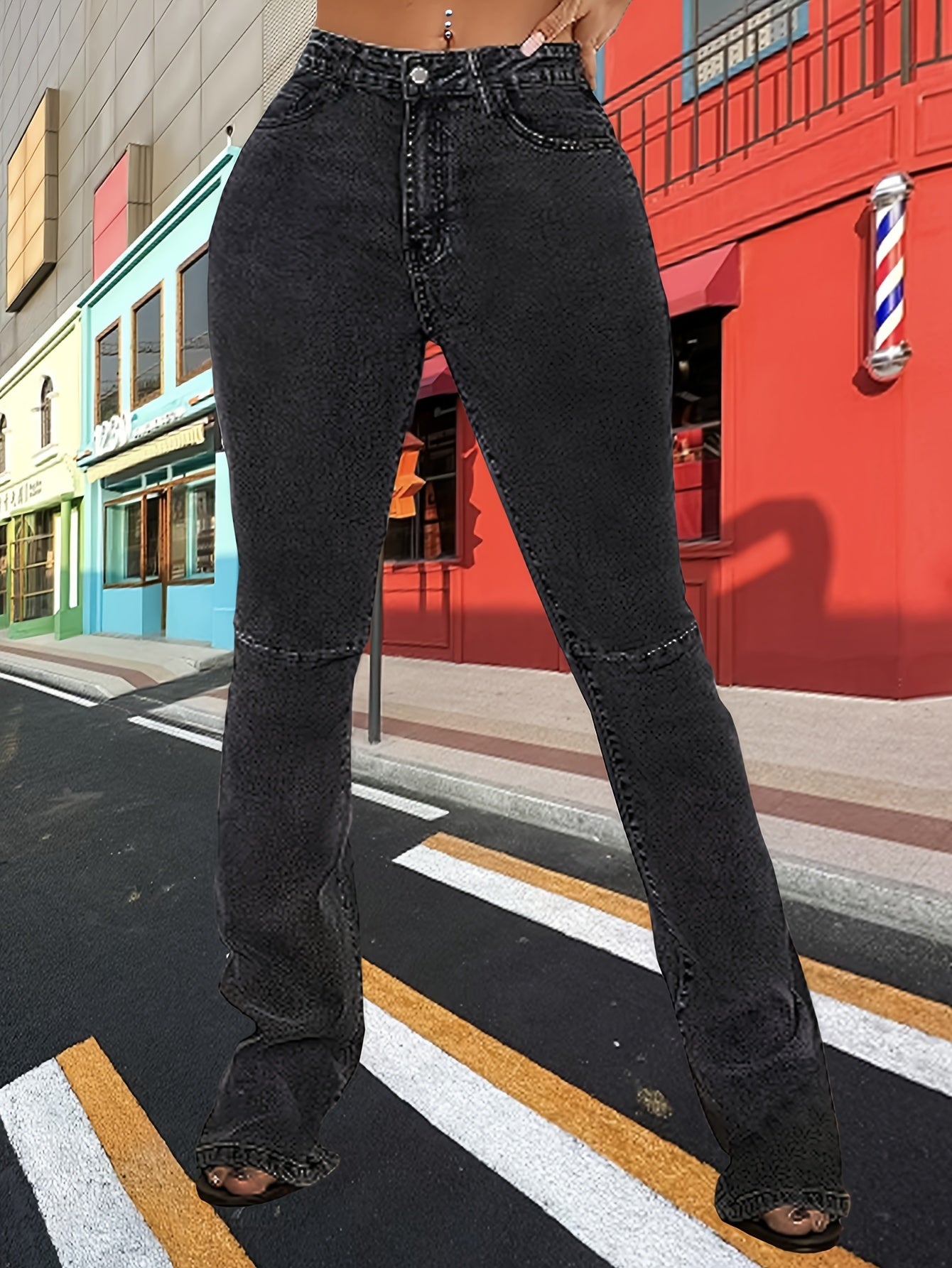 Women's black plus size high waisted bell bottom jeans, stretch denim flare pants with split hem, worn by a curvy figure on the street.