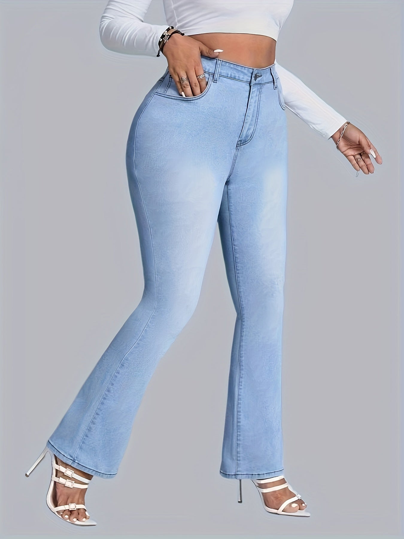 Chic plus size women’s flare jeans in light blue denim, featuring embroidered butterfly details, perfect for casual and all-season wear.